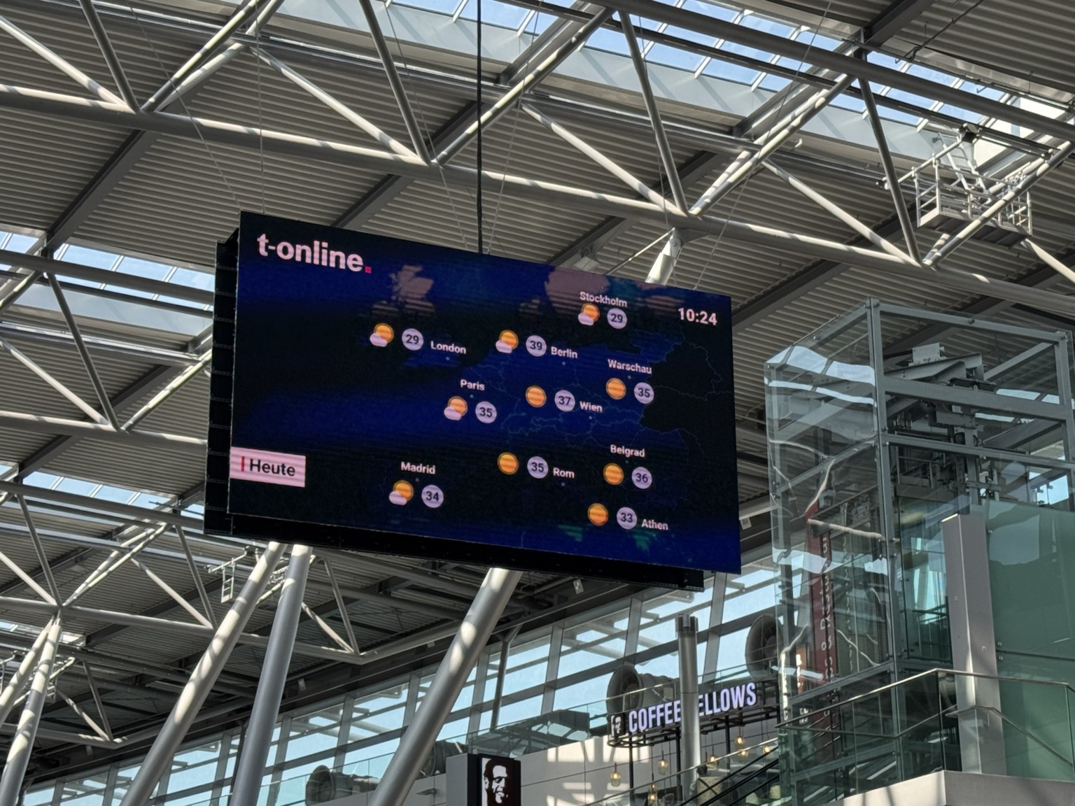 Amtliche Hitzewarnung auf der Videoleinwand am Flughafen Düsseldorf: Berlin 39 Grad, Athen 33 Grad